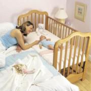 Cuna al lado de la cama de los padres