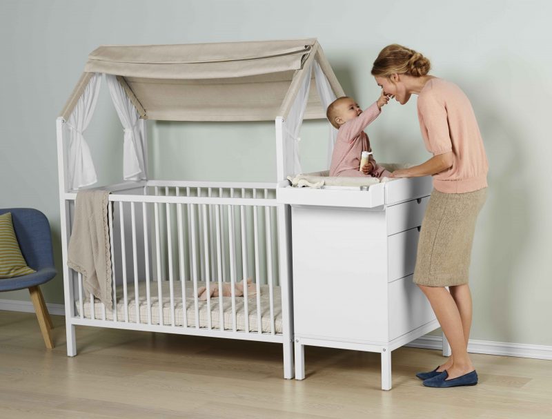 Stokke® Home™ Bed with Roof textiles, and Stokke® Home™ Dresser with Changer on top.